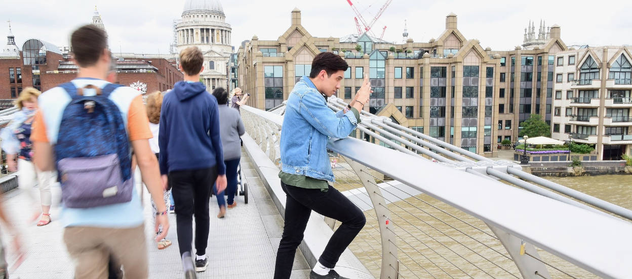 Boy taking a picture on Millenium Bridge london