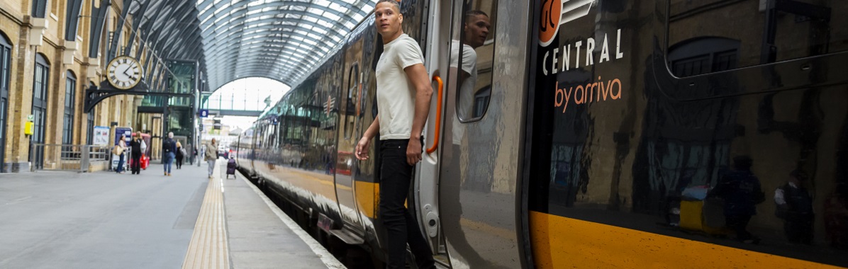 Man stepping off a Grand Central train at London Kings Cross