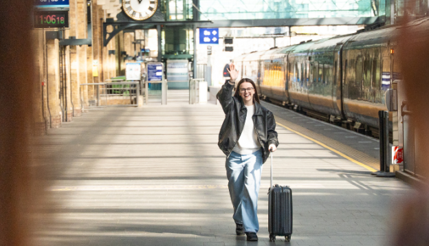 Friends waving meeting up at the train station to catch the grand central train
