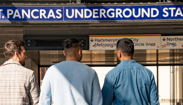 Three friends walking in to London King's Cross St Pancras Underground Station 