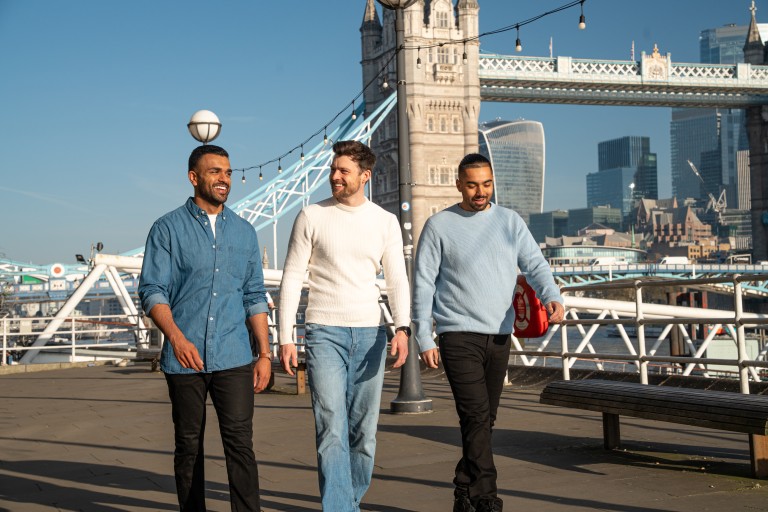 Three friends in London walking across the tyre bridge