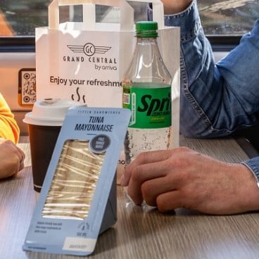 couple sharing a sandwich sat on board a train 