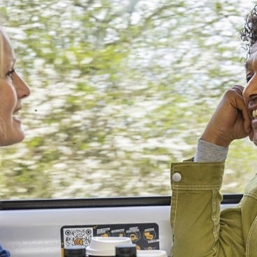 family sat smiling on a train by the window